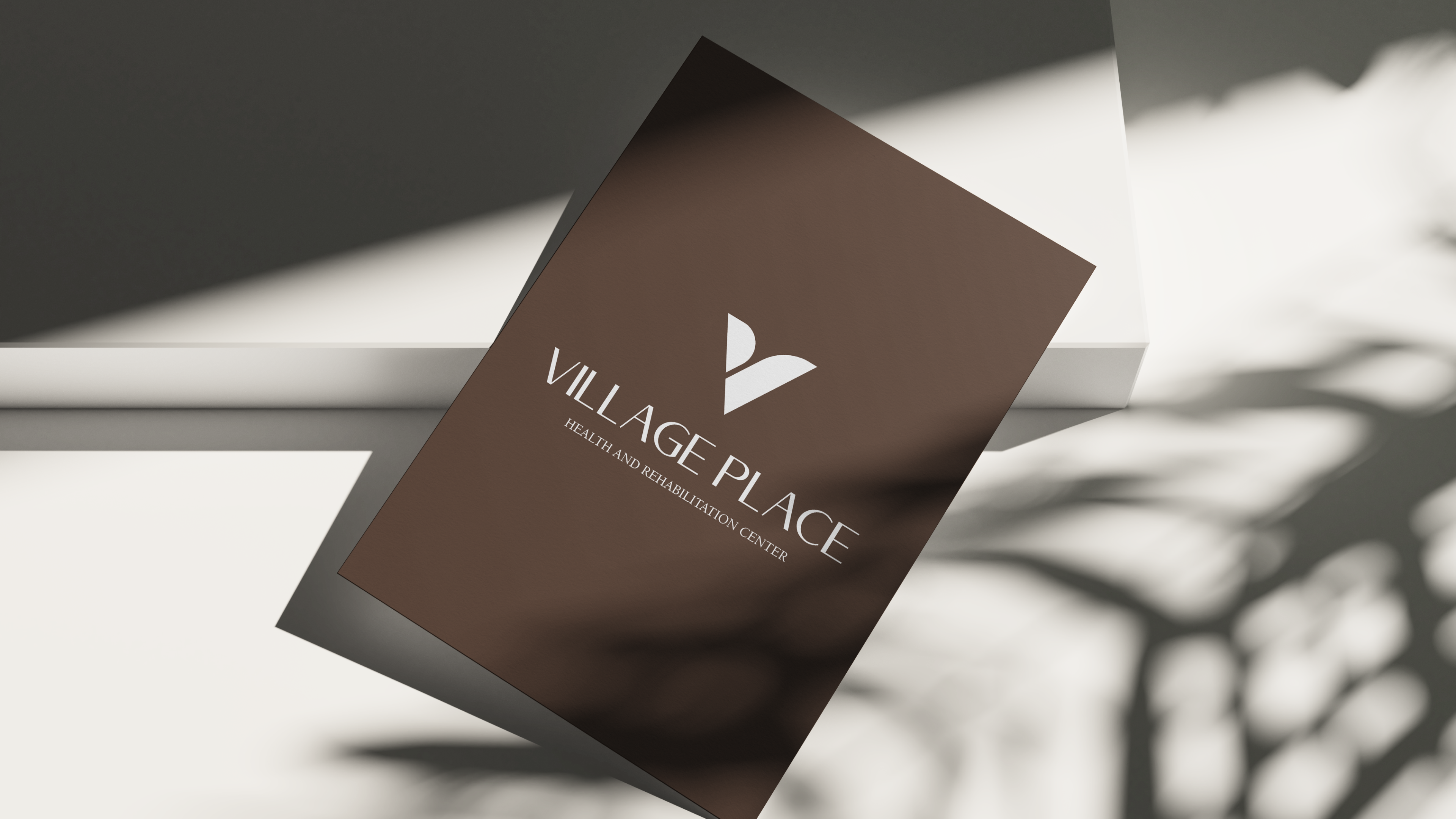 Village Place brochure cover — brown paper with the V mark and serif lockup