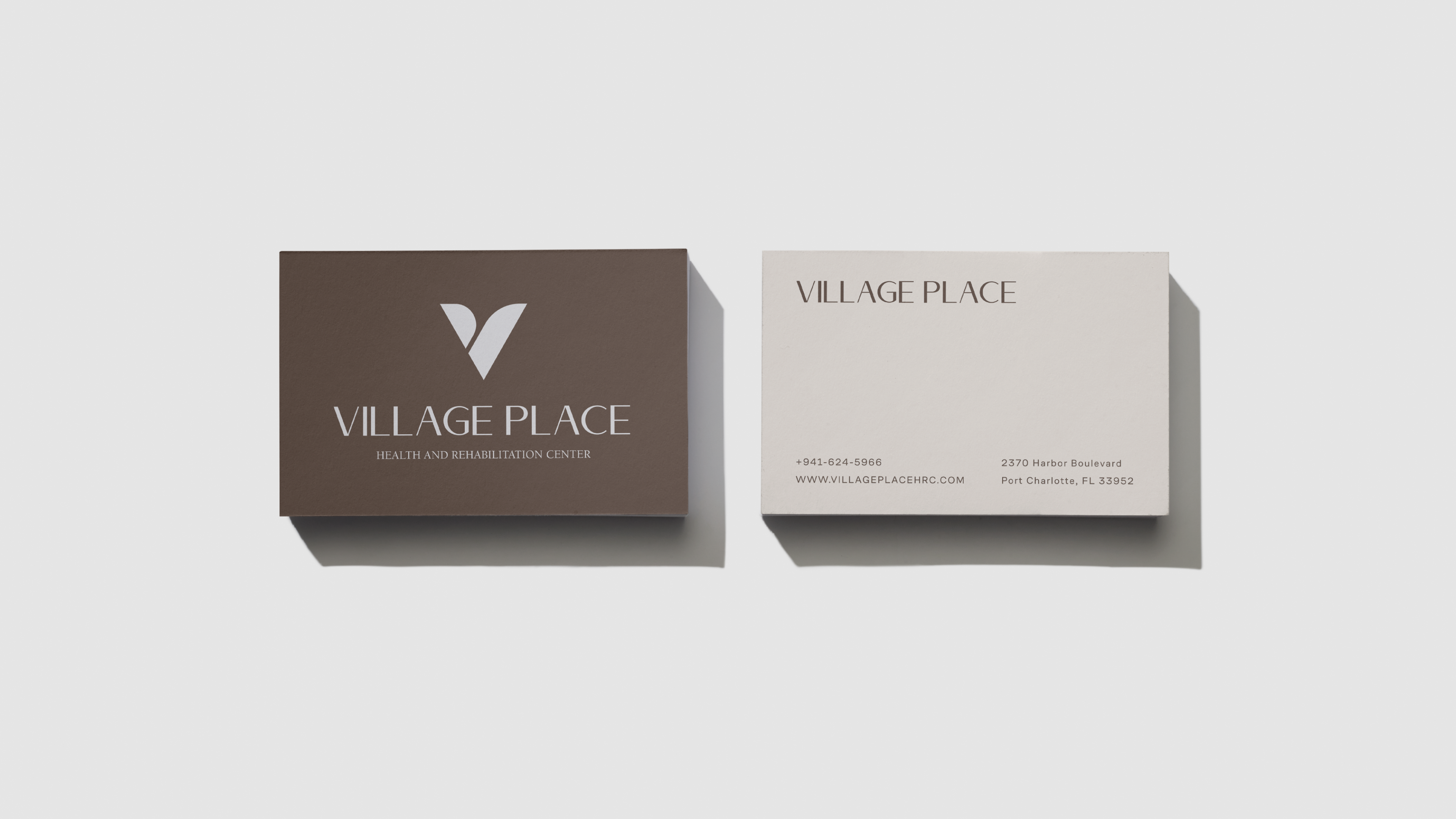 Village Place business cards — brown front with V mark, cream back with contact info